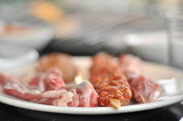 Traditional Cypriot meze and mix meat and chicken kebab table with charcoal barbecue on the table for self cooking during the eating time