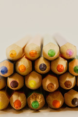 stacked crayons of different colours isolated on a white background