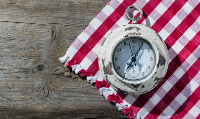 old clock on a red and white napkin on a wooden background