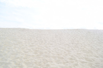 Fototapeta na wymiar Background of white sand and the light sky. Texture.