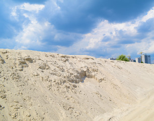 Mountain view from the sand and sky with clouds.