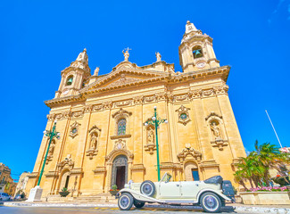 The beautiful retro styled wedding car at the huge medieval Parish Church in Naxxar town, Malta