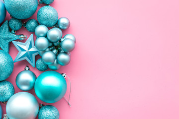 Christmas tree toys background. Blue balls and stars on pink background top view space for text border