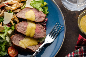 Salad with warm beef with oyster mushrooms, tomatoes and greens. Top view
