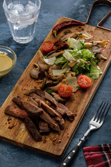 Salad with warm beef with oyster mushrooms, tomatoes and greens.