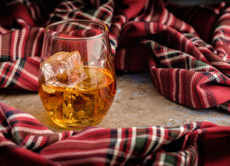 Still-life with a glass of bourbon. A glass of whiskey with ice. Concept of autumn spleen