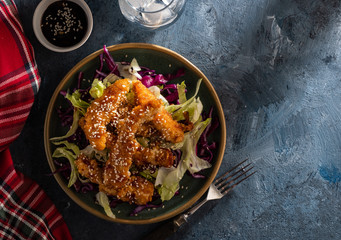 Salad with warm glazing chicken, sprinkled with sesame seeds. Chinese cuisine. Asian culture
