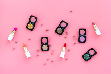 Professional cosmetics set with palette of eyeshadows on pink background top view copyspace