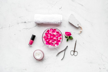 Obraz na płótnie Canvas tools for manicure with spa salt and rose on white stone background top view space for text