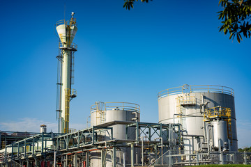 Close up Industrial view at oil refinery plant and silos form industry zone with blue sky