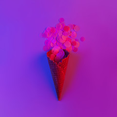 ice cream cone with glitter on pink neon background.