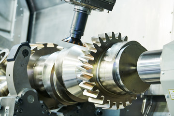 cogwheel on shaft milling process. Industrial CNC metal machining by vertical mill