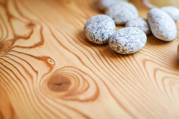 Close up Group of white and grey pebbles texture in daylight on wooden background.