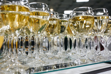 Sommelier pours champagne from a bottle into a glass at the table in the restaurant