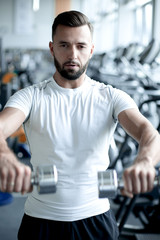 Fototapeta na wymiar close up.stylish young man working with dumbbells in the gym.