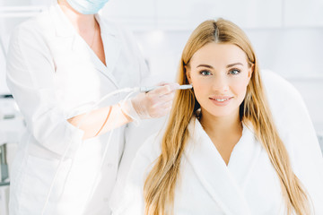 Young blonde female beauty getting effective removal treatment on her skin, such as dermabrasion, gas-liquid peeling during a visit in beauty salon