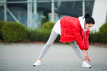 Fitness woman doing workout standing in a modern building background