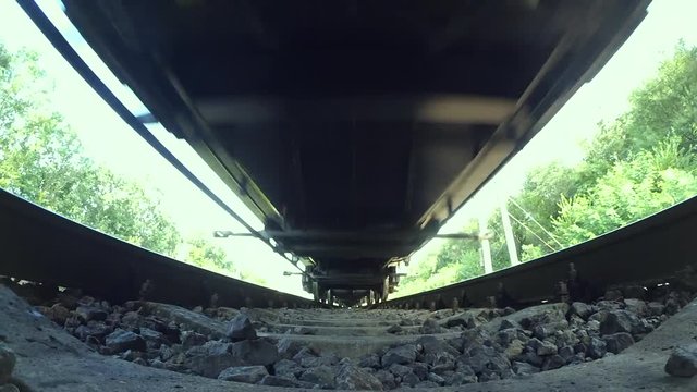 Passing train bottom under view wide angle close-up. Railroad tracks railways train transport system fast speed