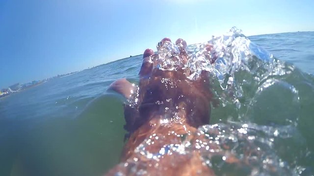 Slow motion POV. Scene point of view the hand glides slides on the surface of the water on a sunny day with natural sunny light rays close-up. Ocean sea summer concept