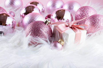 Pink Christmas decorations on white fur background