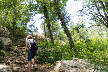 Naklejka na ściany i meble blonde woman hiking in the wild ardeche in france a small path