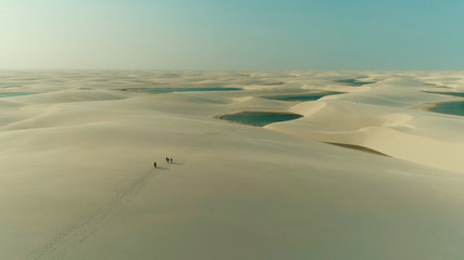 Group of tourists s walking in Lencois Maranhenses National Park in Brazil