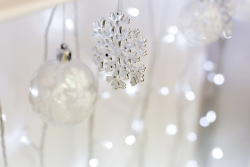 Transparent Christmas tree toy and snowflake on the background of garlands. Christmas background. Decorations for the Christmas tree. White background for new year.