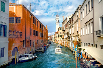 Historic buildings and leaning bell tower of San Giorgio on canal in Venice. Italy