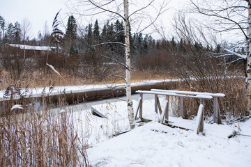 Winter landscape Finland, Northern Europe. Wooden bridge on the winter river