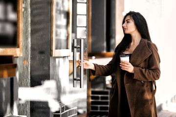 Beautiful girl drinks coffee, sitting in a cozy cafe.
