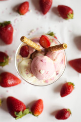 A cup of ice cream with strawberries and rolled wafers. ice cream closeup.