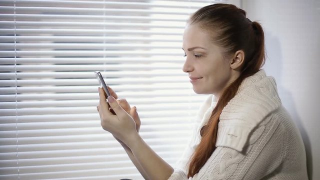 online shopping, a young woman browsing the goods in the online store on the smartphone screen