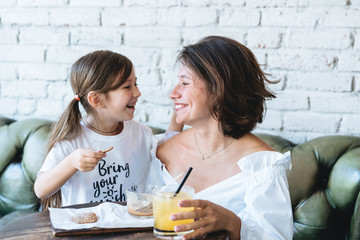 Mom and her little girl have fun on the couch