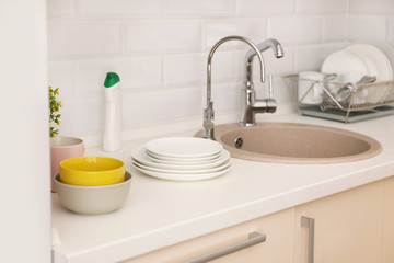 Clean dishes on counter near kitchen sink indoors