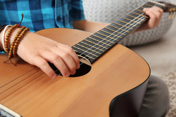 Little boy playing guitar on floor, closeup