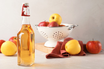 Composition with bottle of apple vinegar on table. Space for text