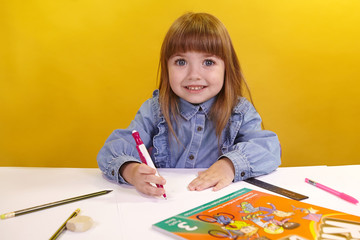  Girl child in glasses reads a book draws writes smiling