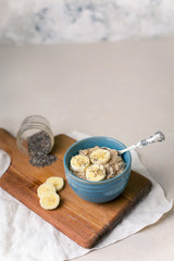 Oatmeal Porridge in a Blue Bowl with Sliced Bananas and Chia Seeds