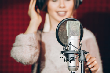 necessary thing for recording song. people, girl is keen on music.