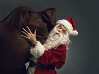Santa Claus carrying a sack with Christmas gifts