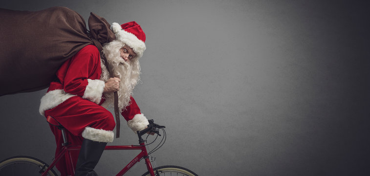 Santa riding a bicycle and carrying gifts