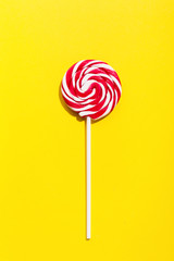 Red lollypop on yellow background