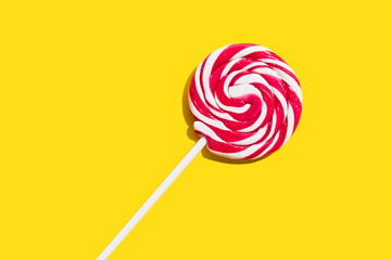 Red lollypop on yellow background