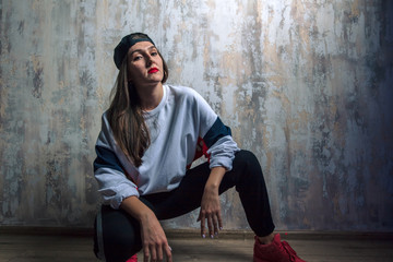 serious cool hip hop dancer in stylish outfit sitting on the floor. close up photo. rest, free time...