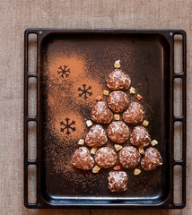Сhristmas tree made from gingerbread cookies on black background with empty copy space for text. Holiday celebration and cooking concept. New year and christmas postcard.