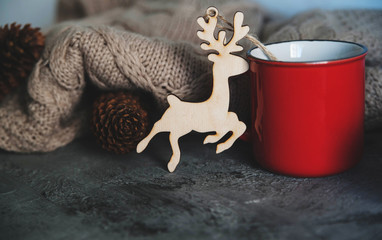 Christmas set. Red cup and wooden toys on stone background.

