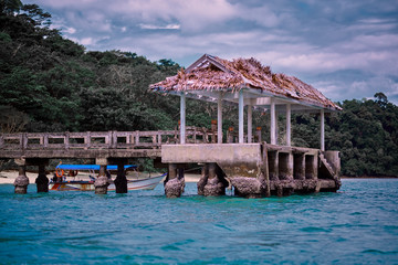 Obraz premium Tropical lagoon pier with a lonely boat. View of the Bay with a pier and a lonely boat.