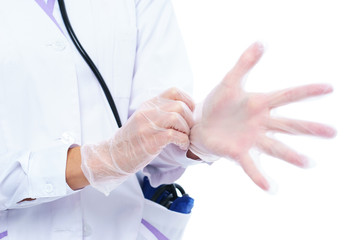 Medical professional, doctor or nurse puts white latex gloves on her hands before being examined, operated on or treated against a white background.