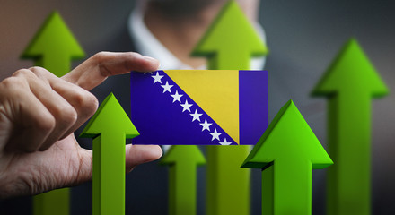 Nation Growth Concept, Green Up Arrows - Businessman Holding Card of Bosnia and Herzegovina Flag