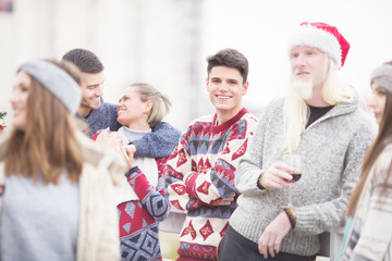 Young friends celebrating Christmas on balcony together